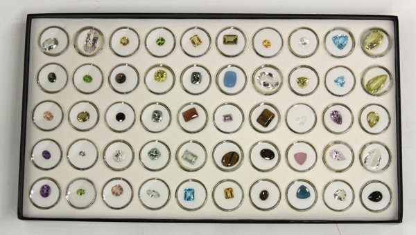 Collection of various loose gemstones: Lot of (6) trays containing approximately (300) loose gemstones of various shapes and sizes, including; sunstone, garnet, rose quartz, amethyst, topaz, tiger's eye, tourmaline, peridot, etc. Includes