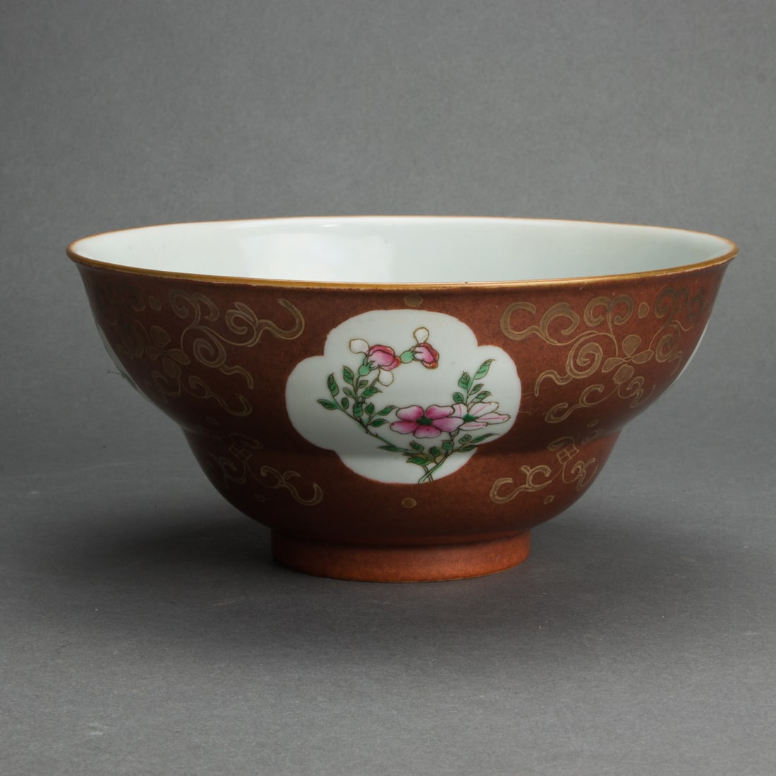 Chinese famille rose and cafe-au-lait ground ogee bowl: Chinese famille rose and cafe-au-lait ground ogee bowl. Decorated with floral reserves and gilt scrolling foliage, bearing a Jiaqing mark in underglaze blue but late 19th century, 7.125" wide.
