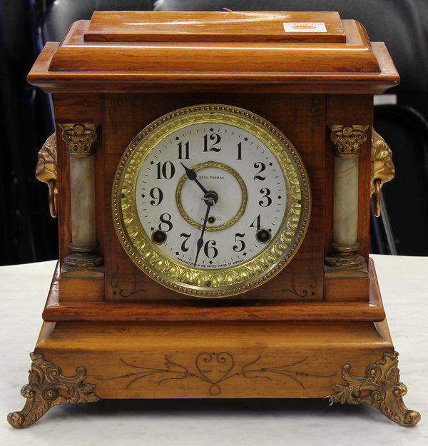 Seth Thomas clock: Seth Thomas Adamantine clock, having a graduated top above the gilt accented dial having Arabic markers flanked with columnar pilasters and rising on a footed base, 11.5''h x 12''w x 6.5''d