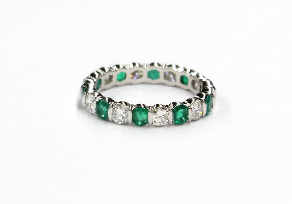 Platinum emerald and diamond eternity band: Emerald and diamond eternity band ring; mounted in platinum (stamped ''Tiffany & Co.''), set with (10) round cut emeralds weighing in total 0.85 ct. and (10) round full cut diamonds weighing in total