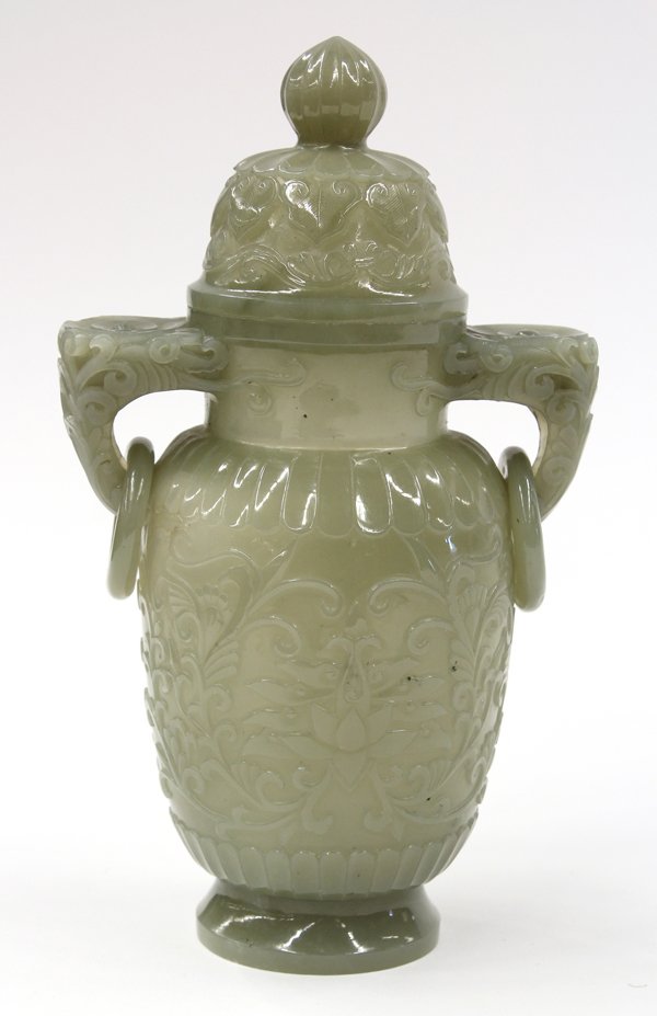 Chinese Mughal Style Jade Urn: Chinese Mughal-style covered jade urn, with angular floral handles suspending loose rings flanking the long ovoid body carved with lotus tendrils within lotus petal bands above a splayed foot, togethe