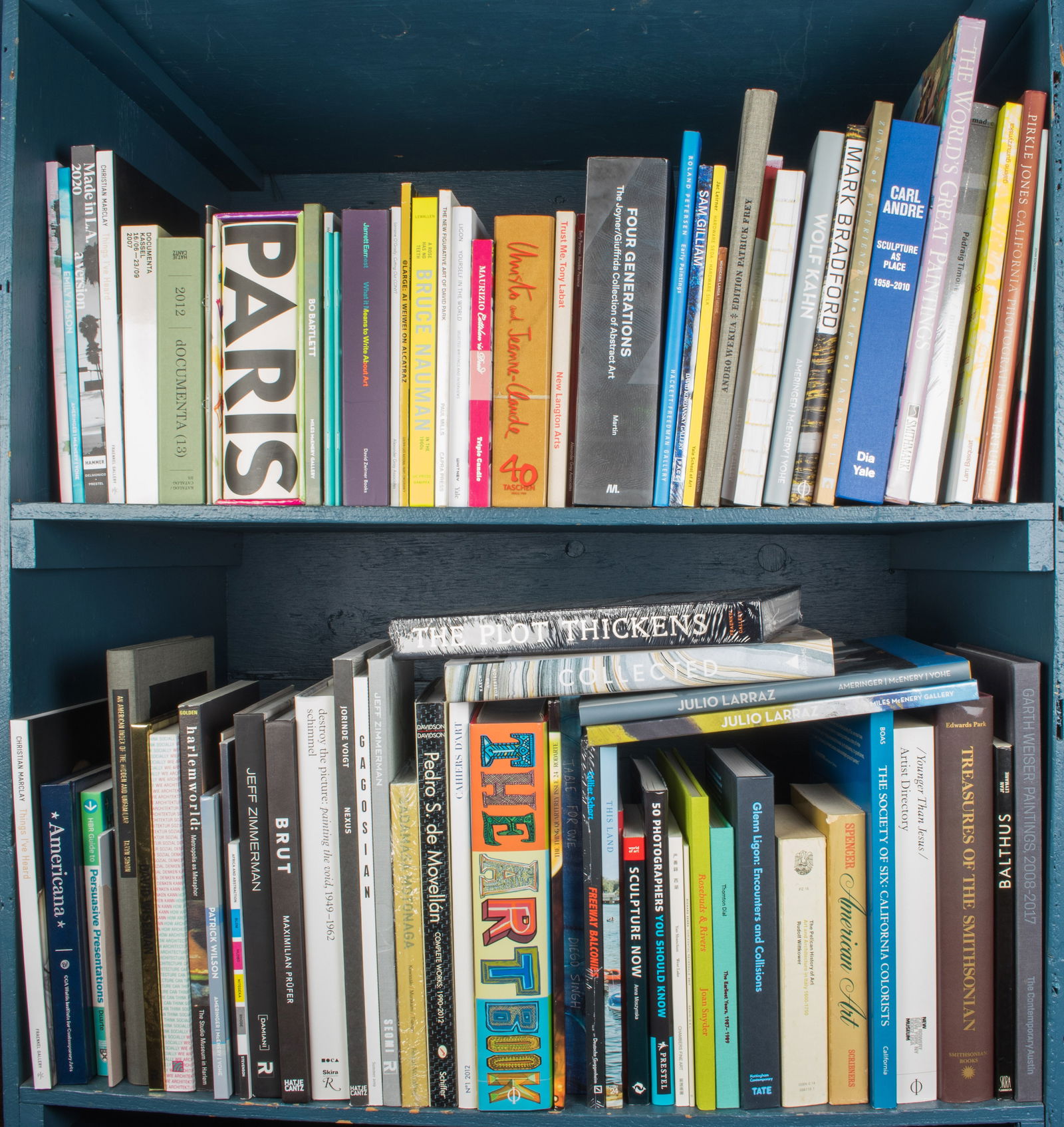 Two shelves of art books: Two shelves of art books, including 'Four Generations: The Joyner/Giuffrida Collection of Abtract Art'; 'Roland Petersen: Early Paintings'; 'Carl Andre: Sculpture as Place 1958-2010'; Wolf Kahn'; 'Ola