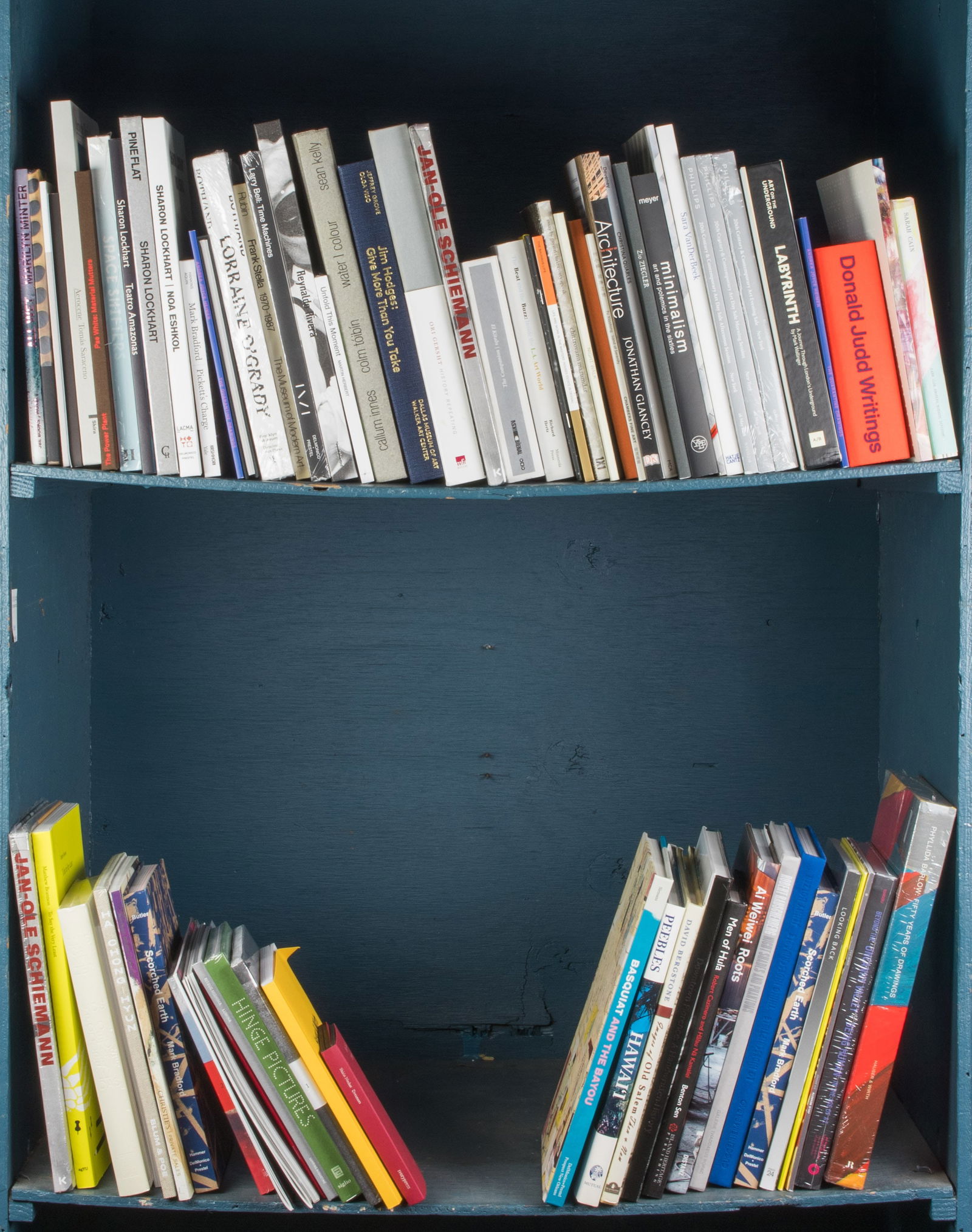 Two shelves of art books: Two shelves of art books, including 'Jan-Ole Schiemann'; 'Ori Gersht: History Repeating'; 'Jim Hodges: Give More Than You Take'; 'Lorryaine O'Grady'; 'Sharon Lockhart'; 'Basquiat and the Bayou'; 'Ai W