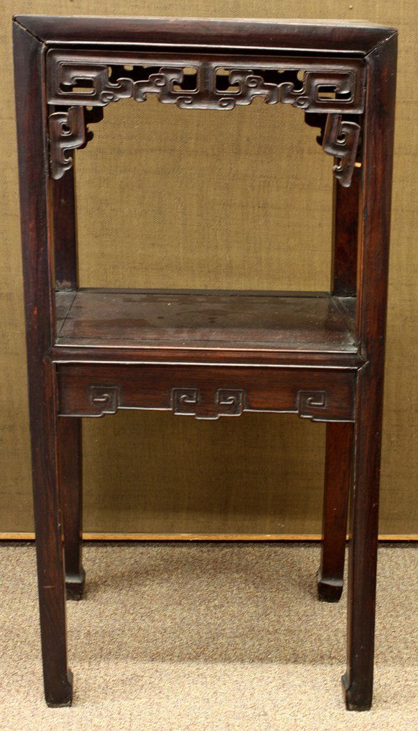 Chinese Tiered Wood Stand: Chinese hardwood tiered stand, the openwork apron pierced with scrolls framing the lower tier which is connected to the straight supports on hoof terminals, 34.5''h x 17''w x 12.75''d