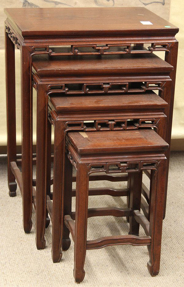 Set of Chinese Nesting Tables: Set of four Chinese wooden nesting tables, of graduated sizes each with an apron reticulated with a scroll pattern and slender beaded supports with hoof terminals, 27.25''h