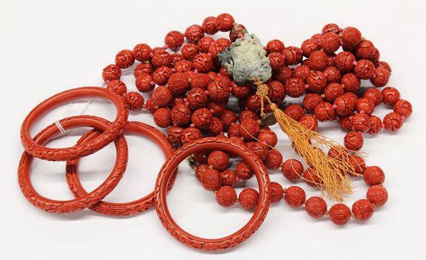 Lot of (8) carved cinnabar jewelry items: Lot of (8) carved cinnabar jewelry items; including (4) carved bead necklaces with silver clasps, (1) with cloisonne bead and jade plaque pendant, and (4) carved endless bangles. (Provenance: from a p