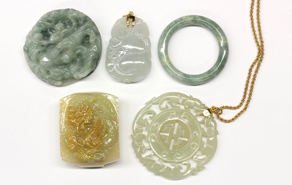 Lot of (5) hardstone carvings and (1) leather box: Lot of (5) hardstone carvings; (1) jadeite medallion depicting pine tree and Shou-lao, god of longevity in a leather box, (1) 2-color jadeite buckle, (1) jadeite pendant with 14K yellow gold bail, (1)