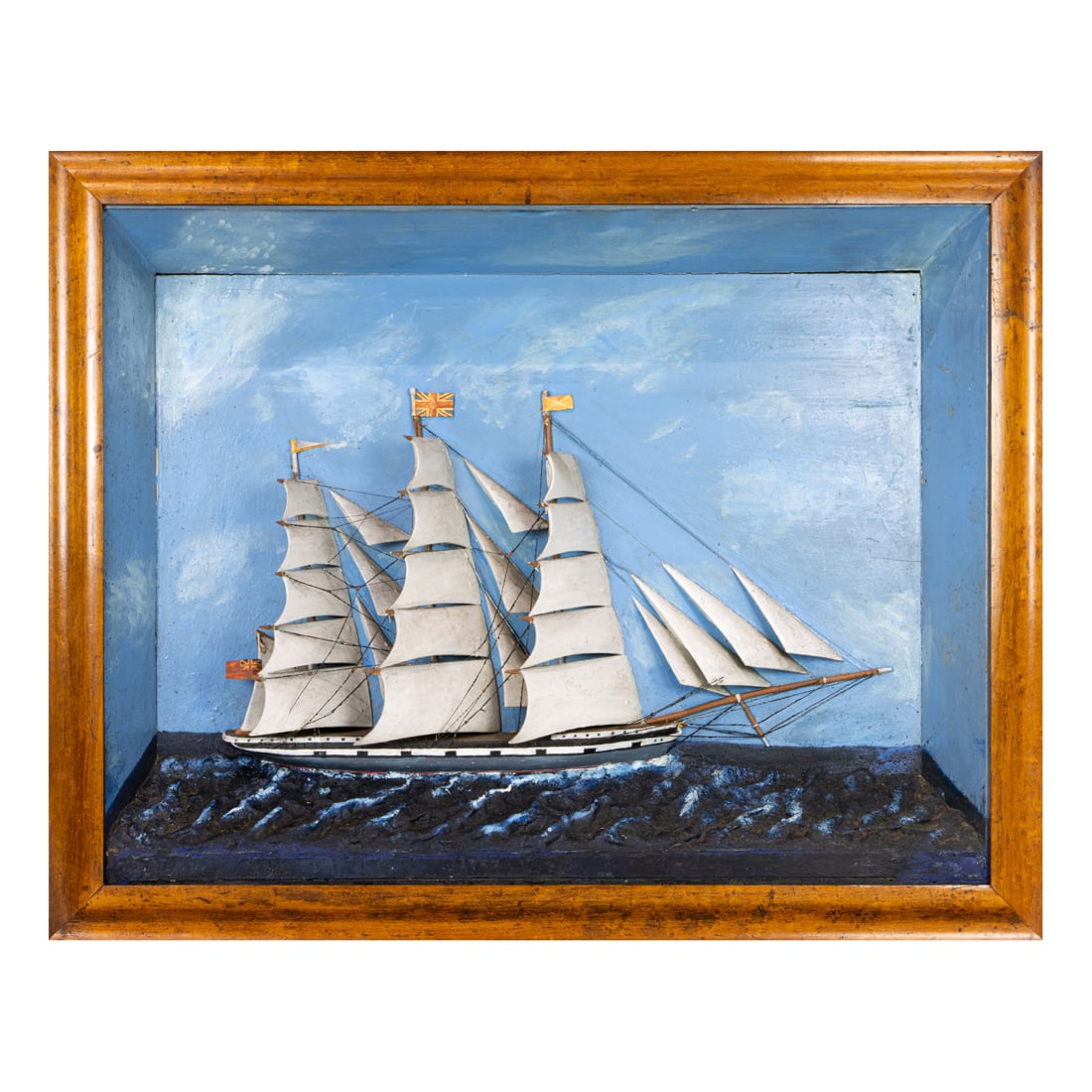 A shadow box model of ship, circa 1900, depicted flying British flag in birdseye maple frame, (1 of 3)