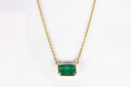 An emerald and 14k gold pendant necklace