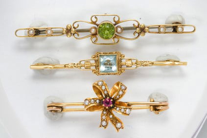 Three gemstone and 14k gold brooches