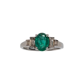 An emerald, diamond and silver ring