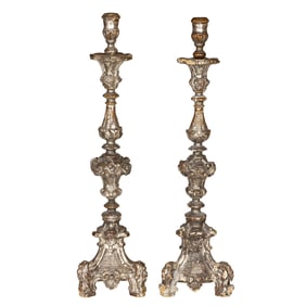 A pair of Continental Baroque silvered gilt candlesticks, 18th century