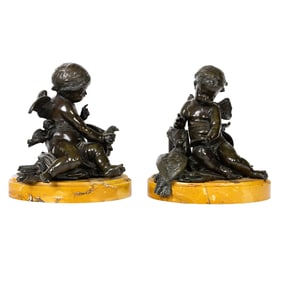 A pair of Continental patinated bronze of putti after Jean-Baptiste Pigalle (French