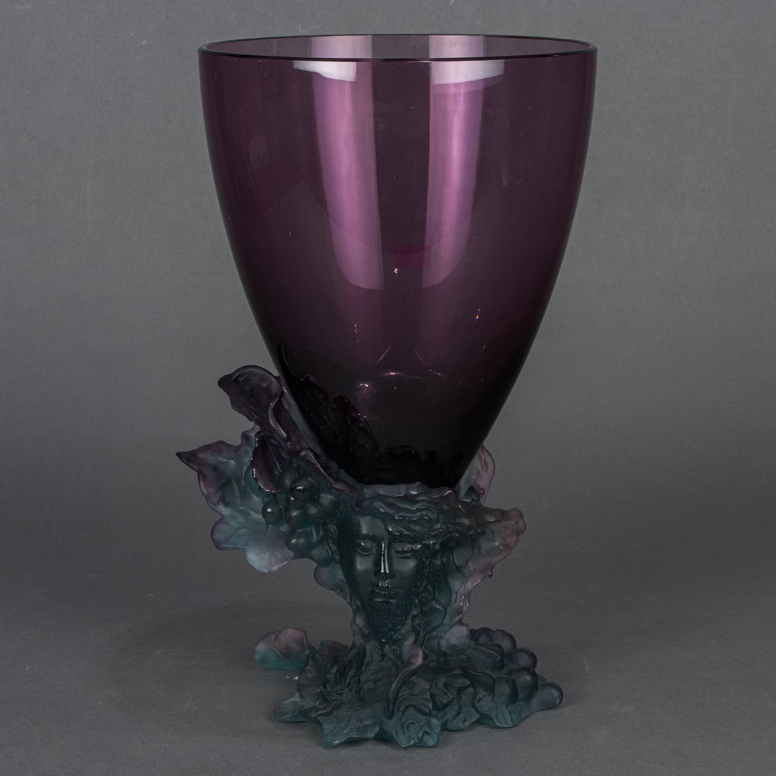 A Daum pate-de-verre and amethyst glass Bacchus vase: A Daum pate-de-verre and amethyst glass Bacchus vase, depicting Bacchus and Meditrina in a grape motif, engraved signature, applied factory label, 14"h