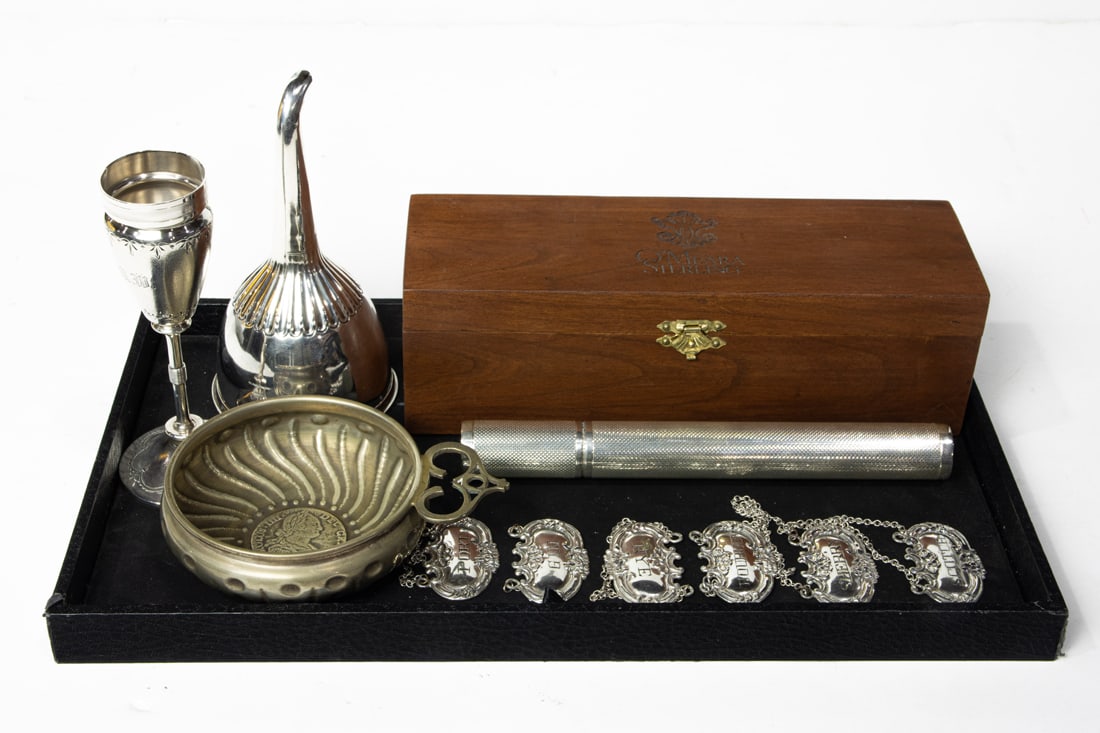 A lot of vintage wine and spirit sterling accessories, including an Georgian wine funnel; six labels: A lot of vintage wine and spirit sterling accessories, including an Georgian wine funnel; six labels with link chains; an O'Meara cigar case 8"l with its retail cedar box; en suite with a French wine 