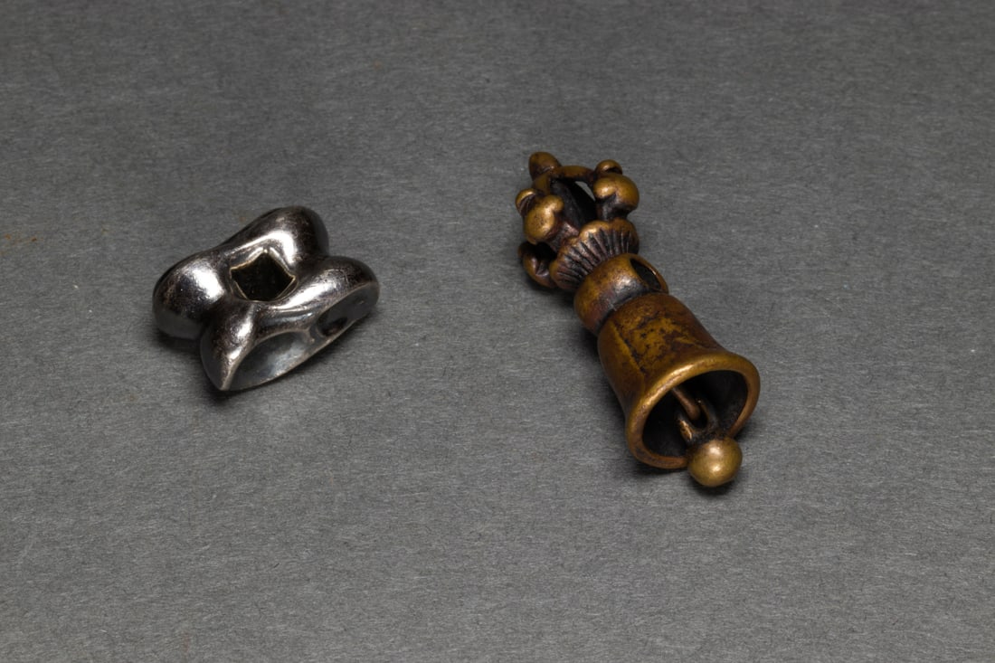 (lot of 2) Tibetan Buddhist metal ornaments: (lot of 2) Tibetan Buddhist metal ornaments. From .325" to 1.325 across.