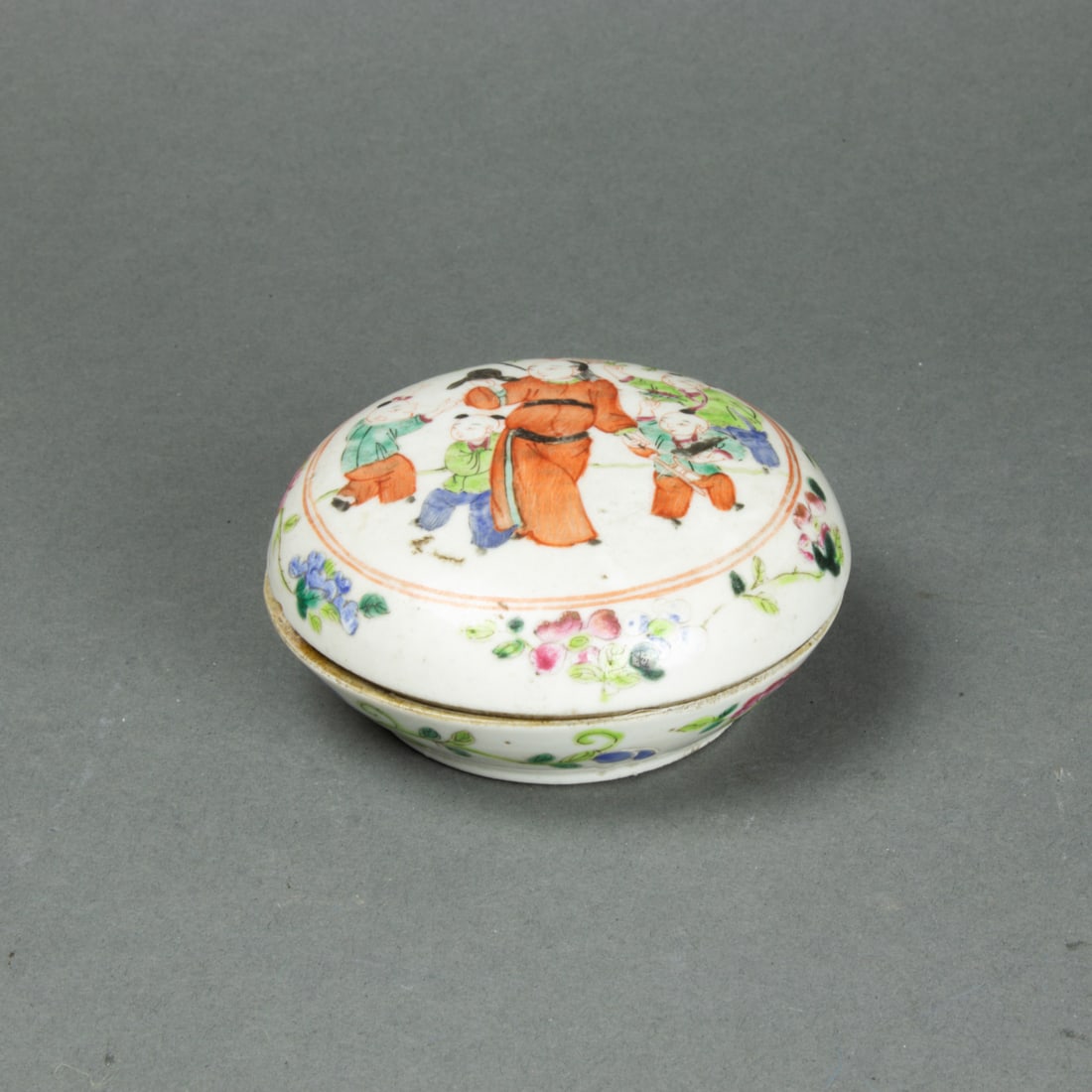 Chinese famille rose circular seal paste box: Chinese famille rose circular seal paste box. Decorated with figures and flower, 4" across.