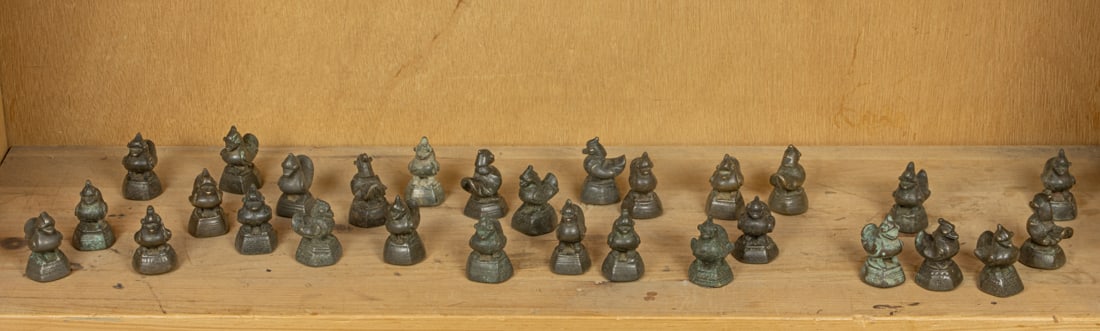 A shelf of Burmese bronze duck-form 'opium' weights: A shelf of Burmese bronze duck-form 'opium' weights. Each weighing approximately 160 grams and measuring 2 inches high.