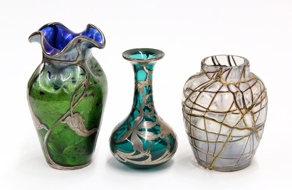 Iridescent art glass group: (lot of 3) Iridescent art glass group, consisting of a silver overlaid vase attributed to Loetz, having a mottled iridescent surface accented with the sterling floral sprays continuing to the circular