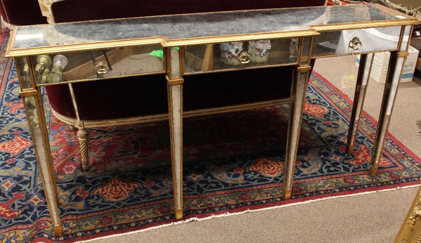 John Richard console table: Hollywood Regency style mirrored console table, executed by John Richard, the breakfront top with giltwood accents framing the silvered three drawer case rising on square tapered legs, retains John Ri
