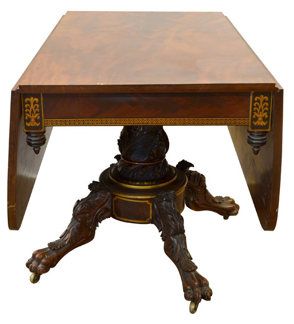 Classical mahogany table: Classical drop leaf mahogany table, circa 1820, the single board top with D form drops above the partial gilt and ebonized apron rising on a paint decorated carved standard terminating on carved paw f