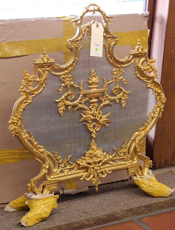 Louis XV style gilt bronze fire screen: Louis XV style bronze ormolu fire screen, of shield form flanked with floral sprays surrounding the urn form medallion surmounting the dore mount and rising on outswept legs, 34.5''h x 32''w