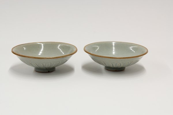 Two Southeast Asian Celadon Glazed Molded Bowls: (lot of 2) Southeast Asian celadon glazed ceramic tradeware bowls, each of the shallow bowls molded with flower petals to the exterior, in contrast with the well which bears a combed pattern, larger: 