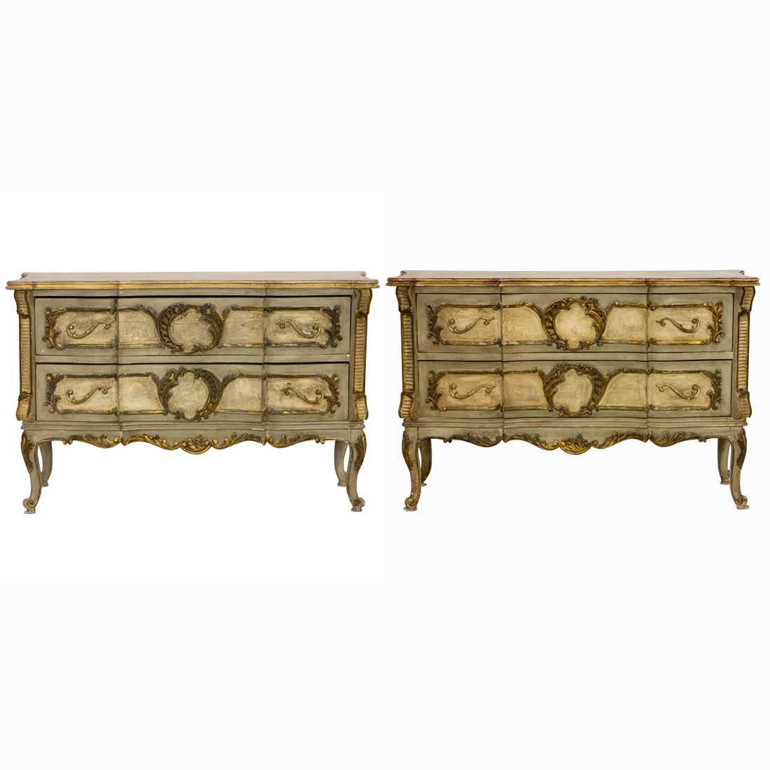 A pair of Neoclassical style partial gilt decorated commodes: A pair of Neoclassical style partial gilt decorated commodes, each having a shaped top above the conforming three drawer case having paneled drawers with gilt pulls and rocaille carved medallions, and