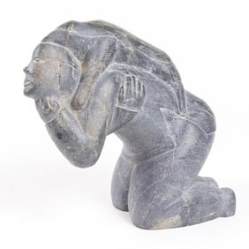 A Nancy Pukingnurk soapstone figure of a kneeling figure with a dog on his back