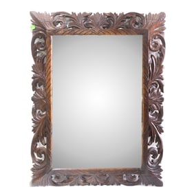 A Baroque style pierced and carved oak mirror with leafy scrollwork