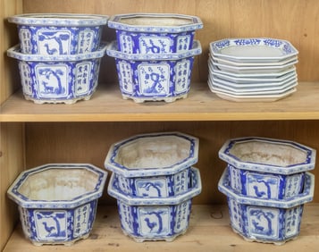 Two shelves of Chinese blue and white jardinieres with stands