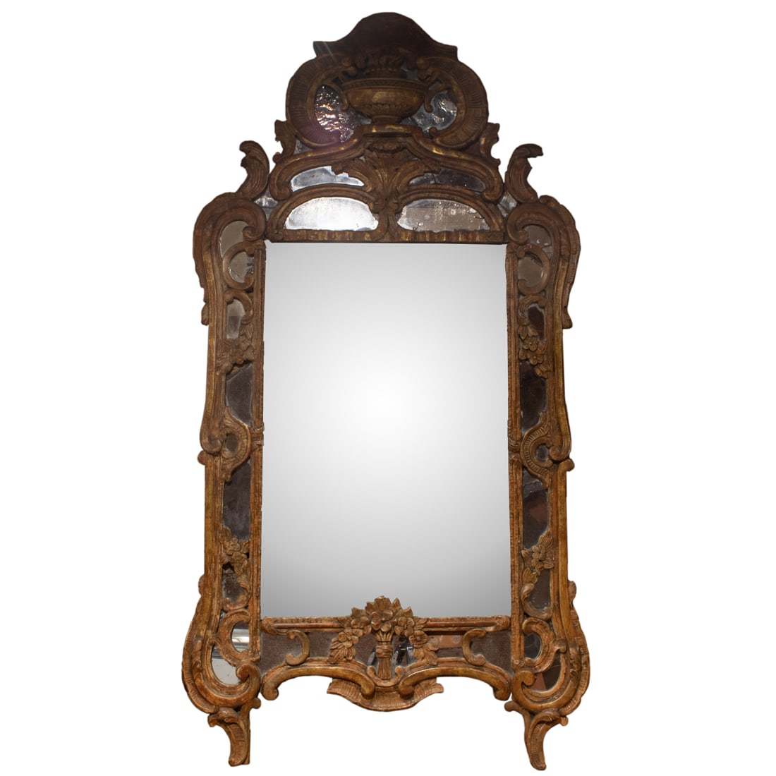 A Baroque style mirror, 19th century, carved with flowers: A Baroque style mirror, 19th century, carved with flowers, and C-scrolls, retains traces of gilt, 50"h x 25.5"w