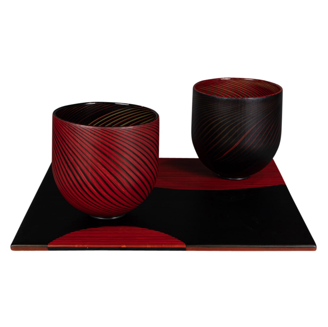 A Steven Klein glass bowl and tray sculpture: Balance 64: A Steven Klein glass bowl and tray sculpture: Balance 64, 2007, glass, composed of two red and black stripe bowls on a square plinth, vessels greatest: 7"h x 7"dia; base: 1.25"h x 18.5"w. Provenance: