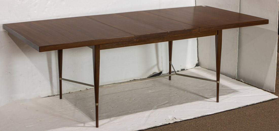 A Paul McCobb for Calvin Grand Rapids wood extension dining table: A Paul McCobb for Calvin Grand Rapids wood extension dining table, circa 1950s, the rectangular top raised on tapered legs with brass stretcher, includes two leaves, marked underside, 28.75"h x 38"w x