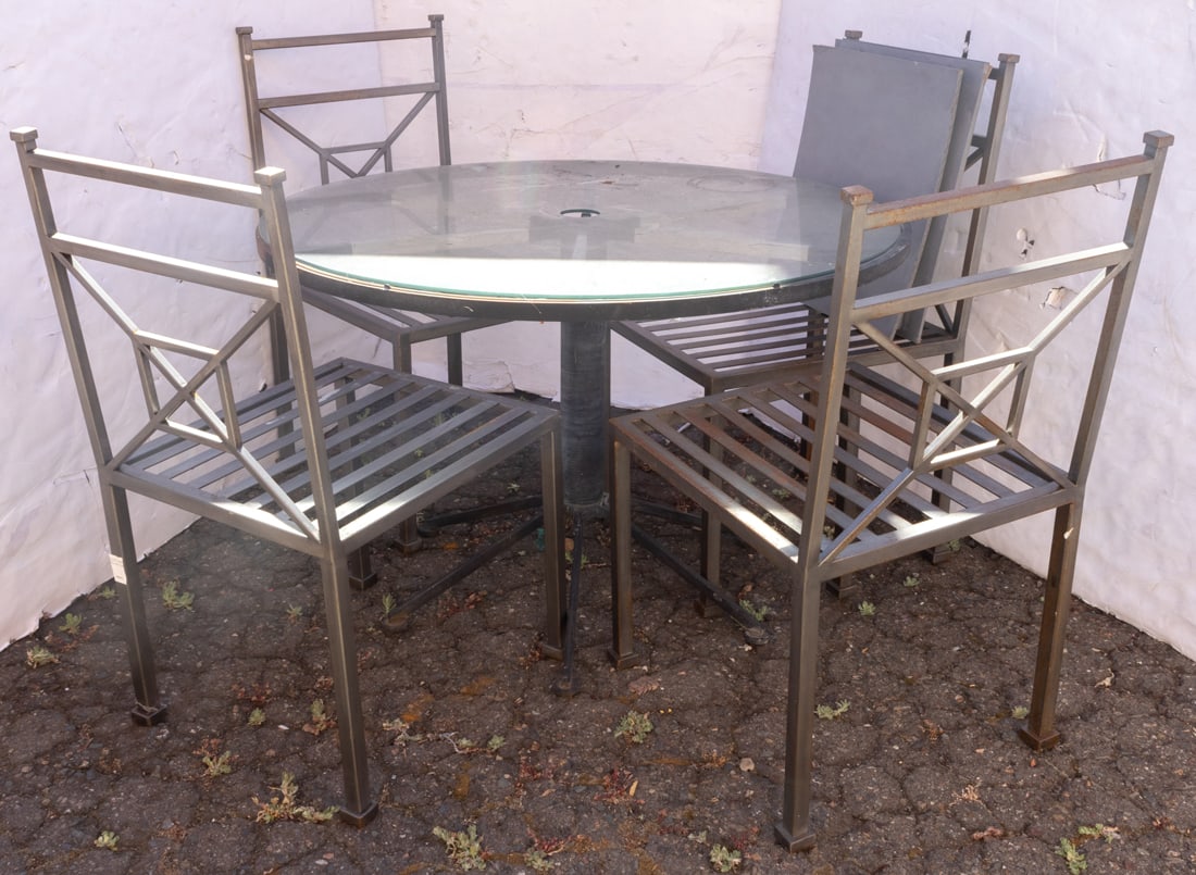 An outdoor glass and metal round patio table and four chairs: An outdoor glass and metal round patio table and four chairs, table 27"h x 41.5"h; chairs; 36"h x 18"h x 18"d, 17.5"h of seat. Provenance: Property from the estate of Mr. Robert Darwin, television and