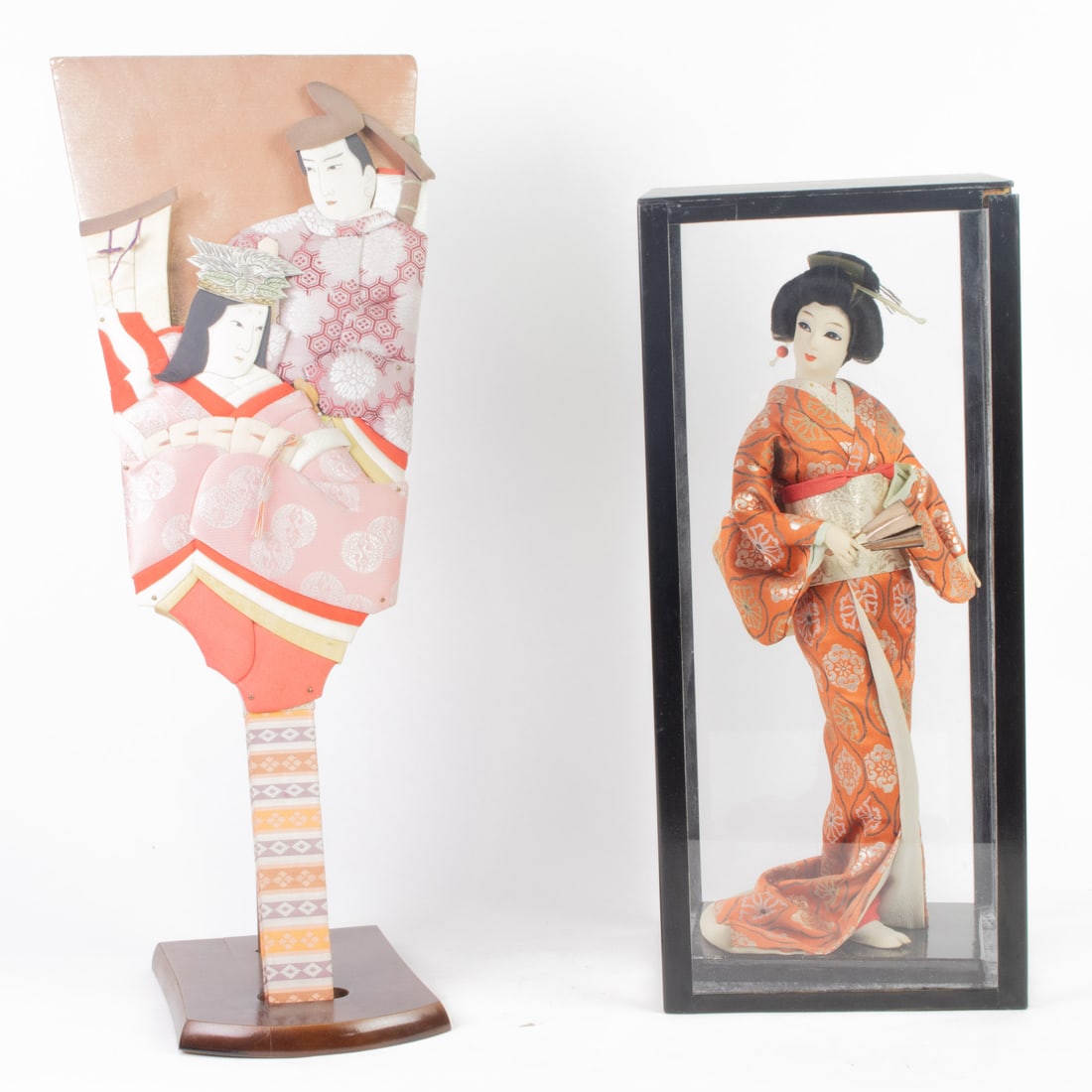 (lot of 2) Japanese decorative objects: (lot of 2) Japanese decorative objects. Comprising of one doll in a glass case and a Hagoita paddle with stand, from 19" to 22.5" high.