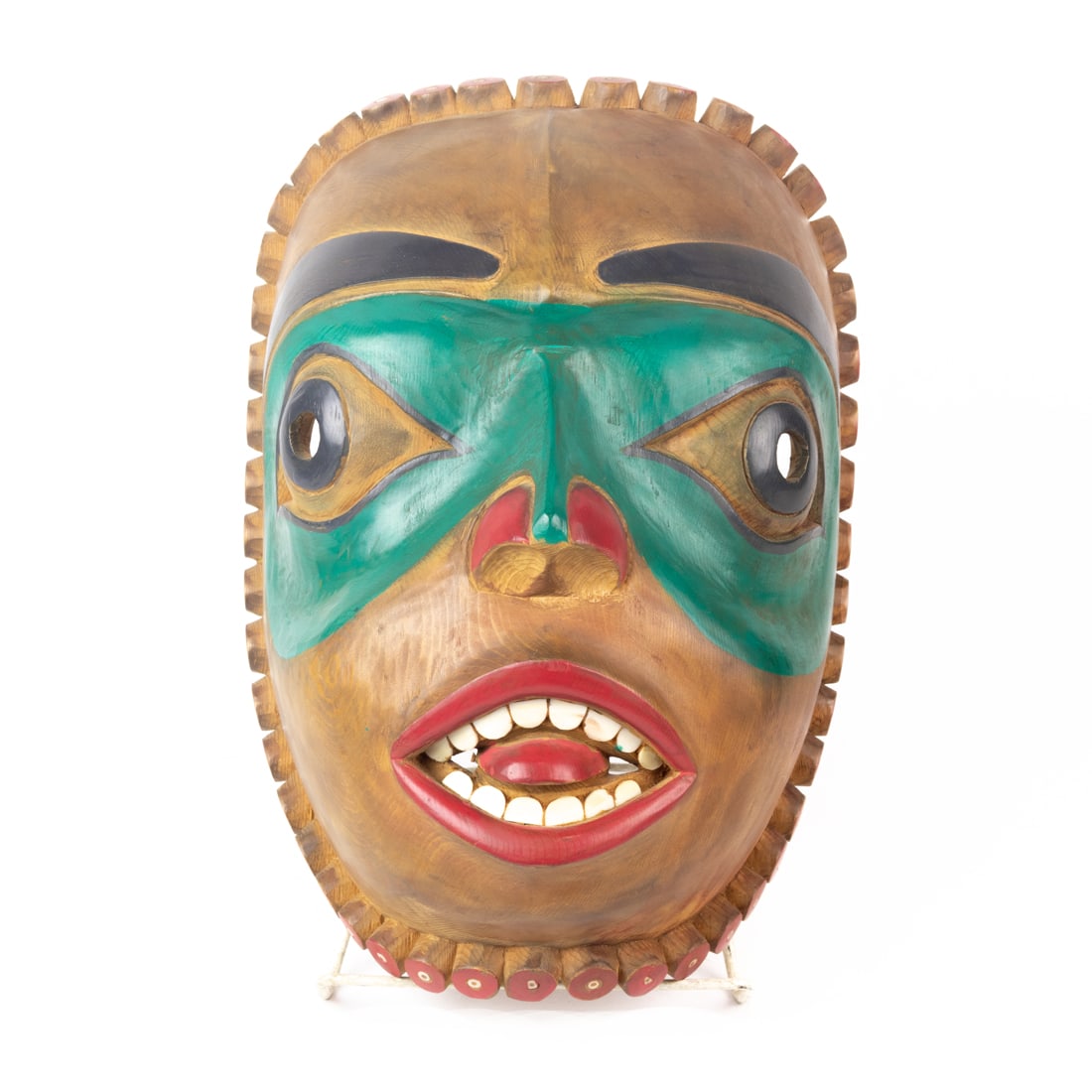 A Pacific Northwest (Kwakiutl, British Columbia) carved wood portrait mask, circa 1990, inset with: A Pacific Northwest (Kwakiutl, British Columbia) carved wood portrait mask, circa 1990, inset with bone teeth and beads, unsigned, 12 1/2"h x 9"w x 7"d. Provenance: the Estate of Charles and Lucy Mart