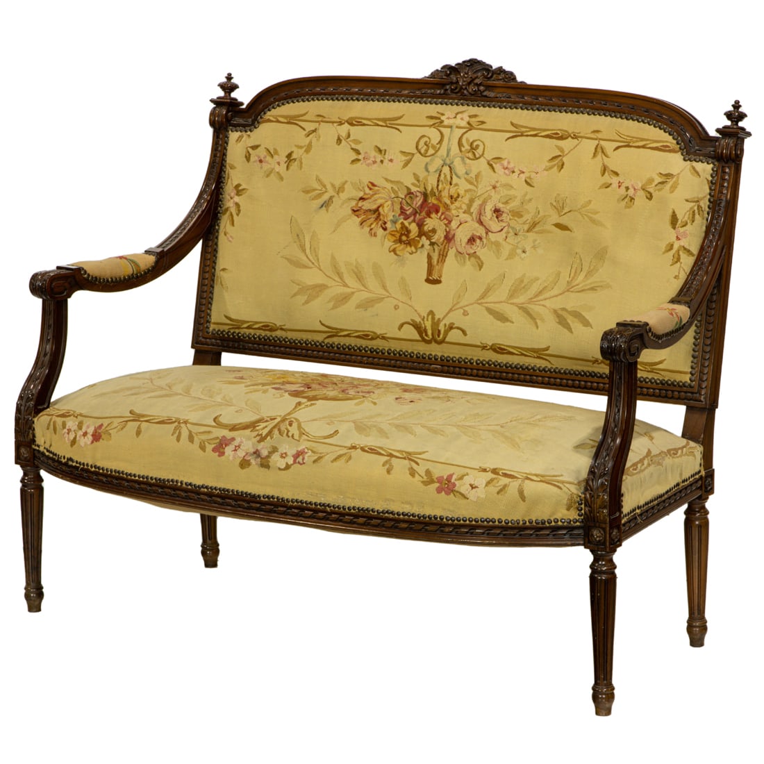 A French Louis XVI settee circa 1920: An associated set of French Louis XVI settees circa 1920, one having a carved bow crest above the petit point seat and back with floral medallions, arms with carved acanthus returns, and rising on par