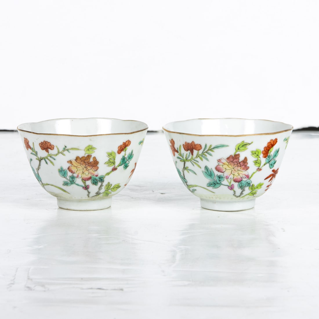 Pair of Chinese famille rose wine cups: Pair of Chinese famille rose wine cups. Featuring floral design, bearing Guangxu four-character mark, 2.375" high.