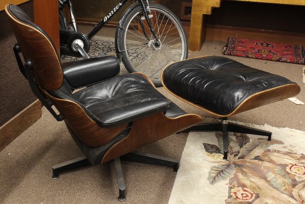 Eames style chair and ottoman: Charles and Ray Eames style model 670 and 671 lounge chair with ottoman, the laminated rosewood frame supporting the leather wrapped cushions rising on an aluminum X form base, chair 32.5''h x 33''w, 