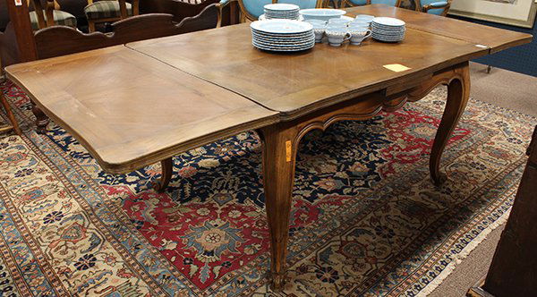 French Provincial style dining table: French Provincial style draw leaf dining table, the serpentine top with two leaves above the shaped and incised apron rising on cabriole legs terminating on upswept feet, 28.5''h x 90''w (extended) x
