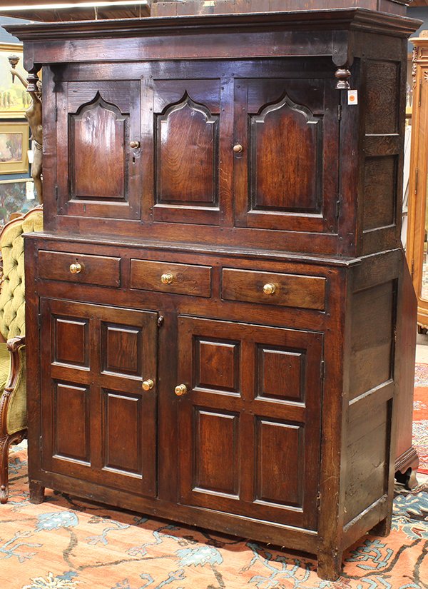 English oak cupboard: English provincial oak press count cupboard, 17th/18th century, with a protruding cornice above the frieze, with drop finials at each end, below three inset panels, two being cupboard doors flanking a