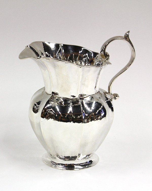 Buccellati sterling silver pitcher: Italian sterling silver pitcher, by Buccellati, the hammered organic form having pinched bulbous body and scroll handle, 8.25''h, 14.25 troy oz.