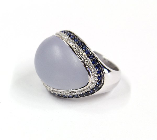 18K gold, chalcedony, sapphire and diamond ring: Lady's blue chalcedony, sapphire and diamond ring; mounted in 18K (tested) white gold, center bezel set with (1) free-form cabochon cut blue chalcedony surrounded by a row of (45) full cut round diamo