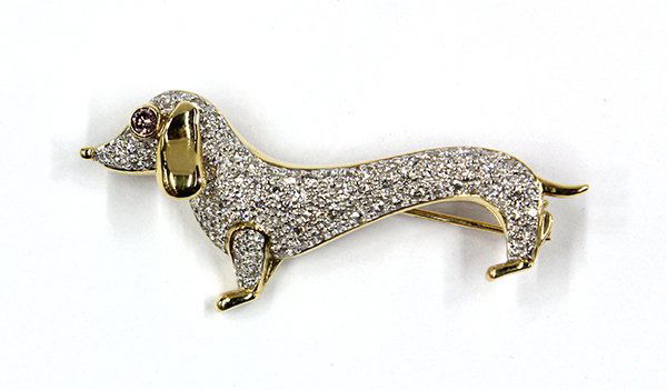 18K gold and diamond dachshund brooch: Lady's pave' set diamond dachshund brooch; mounted in 18K yellow and white gold and pave' set with (100) full cut round diamonds, total diamond weight 1.00 ct., accented with (1) 0.07 ct. Fancy Light