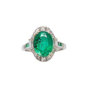 An emerald, diamond and platinum ring
