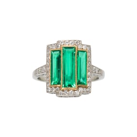 An emerald, diamond and platinum ring