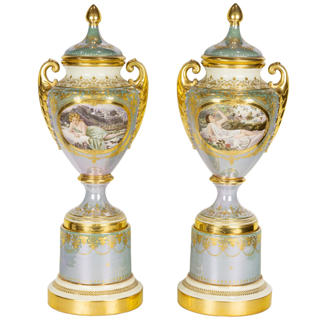 A pair of Berlin style luster decorated porcelain covered urns on stands: A pair of Berlin style luster decorated porcelain covered urns on stands, 20th century, each side painted with recumbent beauty emblematic of the seasons, reserved on an enamel 'jewel' and raised gilt