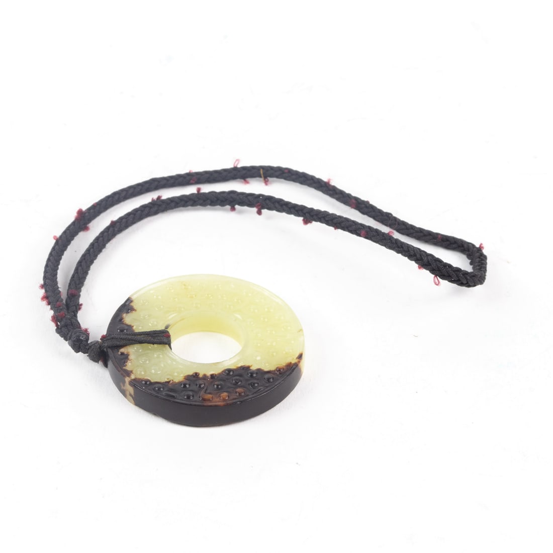 Chinese celadon jade bi disc pendant: Chinese celadon jade bi disc pendant. Carved on each side with a raised comma ground, 1.75" wide