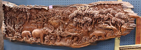 South_East Asian carved wood panel: South-east Asian carved wood panel, the natural rectangular trunk carved in high relief with a scene of wild animals in a jungle setting, 25''h x 6'8''w Provenance: from the collection of the late Rob